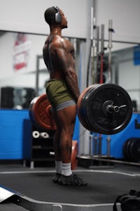 a man lifting a barbell in a gym