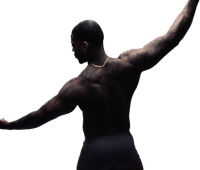 a man with tattoos is dancing on a black background